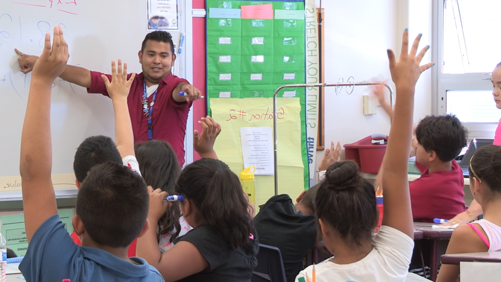 小学教室里的老师举手指着学生.