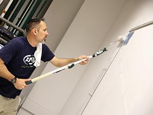 一名志愿者正在粉刷教室的墙壁.