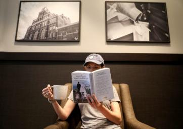 一个人拿着一杯咖啡在看书